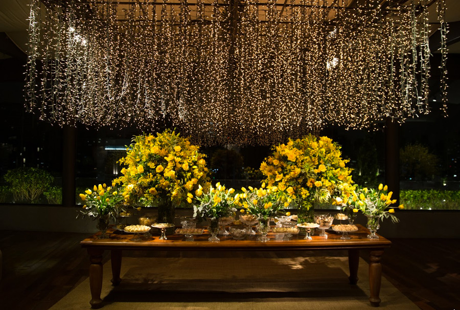 Mesa de doces decoração com luzes e flores amarelas Trio Pérgola